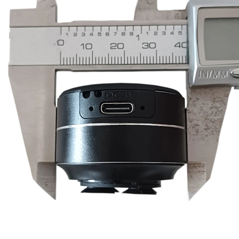 Black cylindrical object with USB-C port on a caliper for measurement
